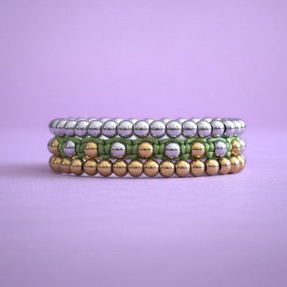 Stack of three beaded bracelets on a purple background