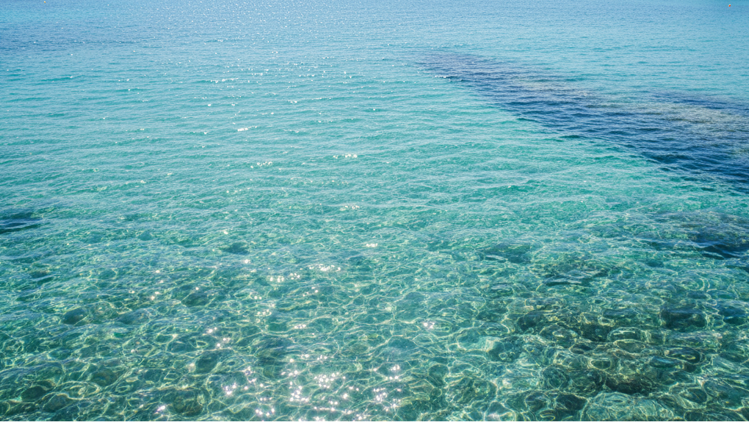 Clear turquoise water with a gradient from light to dark blue.