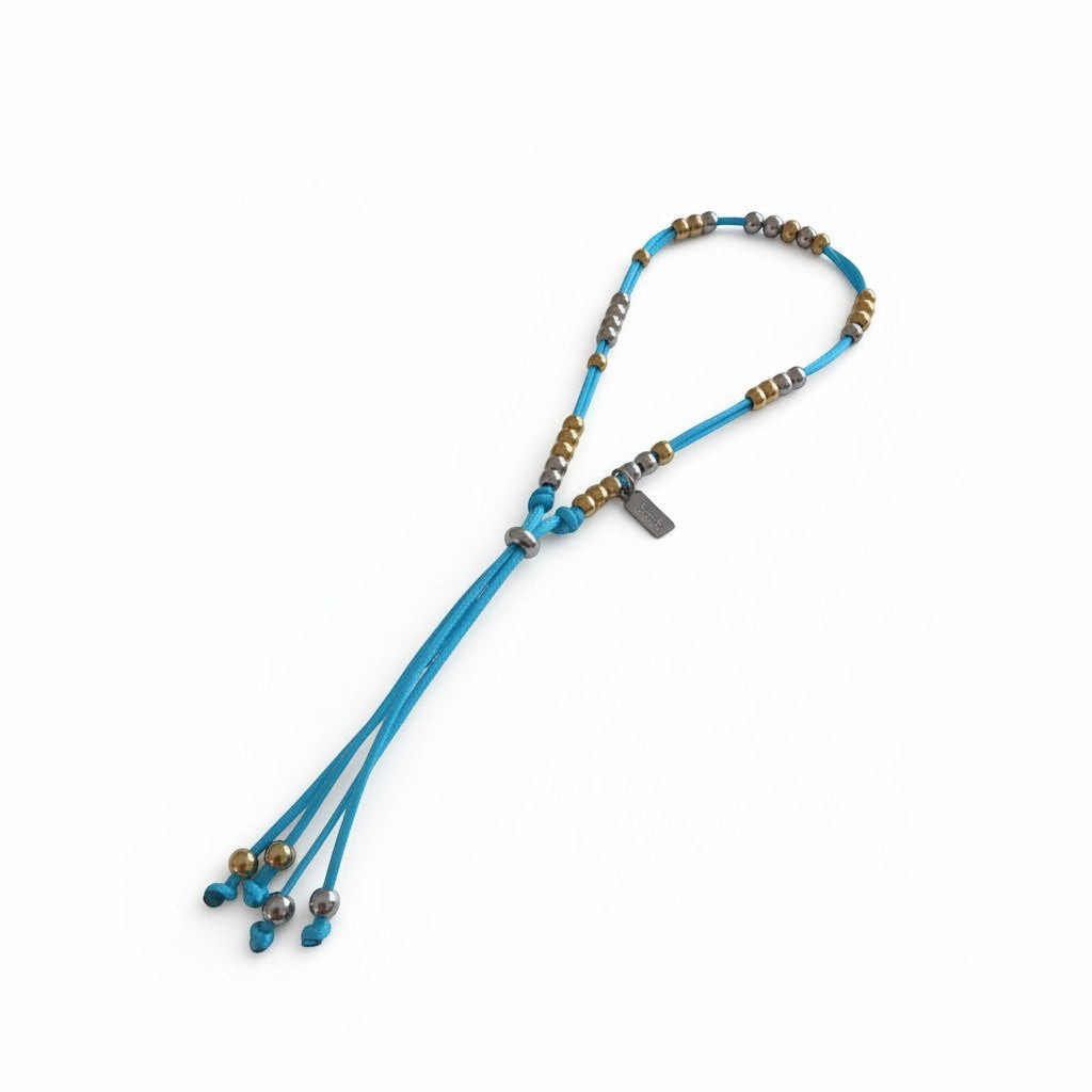 Made by Mothers Luna Anklet featuring a vibrant blue satin cord with hypoallergenic stainless steel and gold beads.